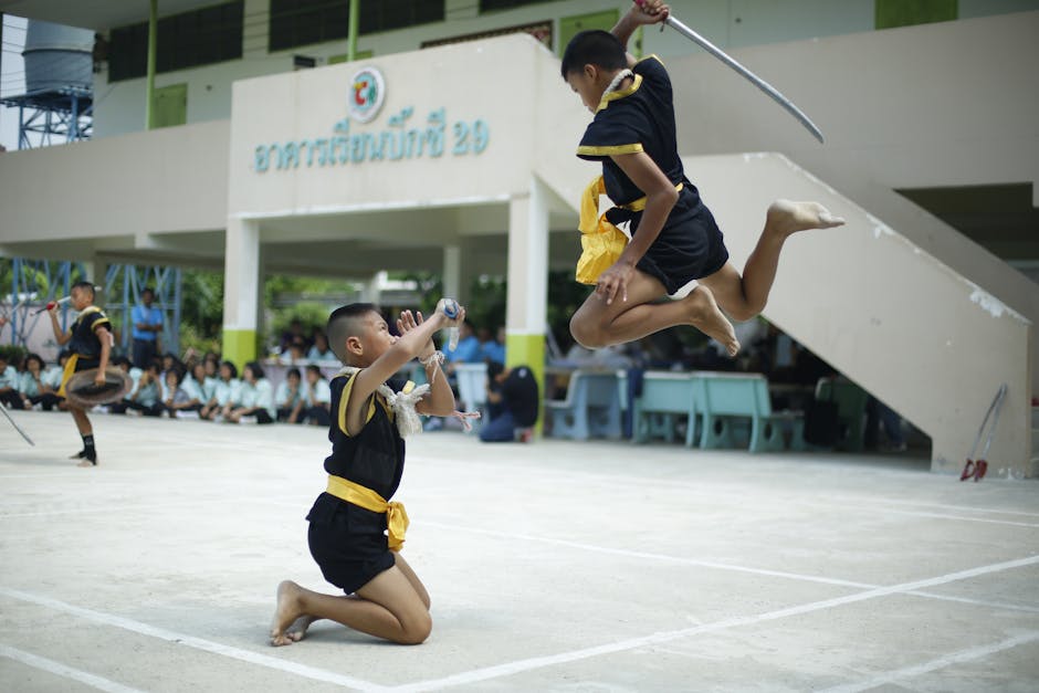 Energetic swordplay by young martial artists in a public demonstration setting.