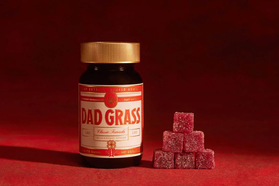 Jar of Dad Grass CBD gummies with stacked red gummies.