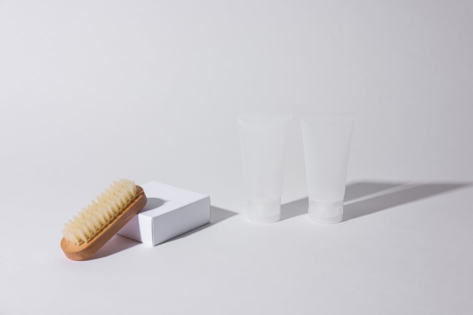 Simple arrangement of a brush and tubes on a white background with shadows.