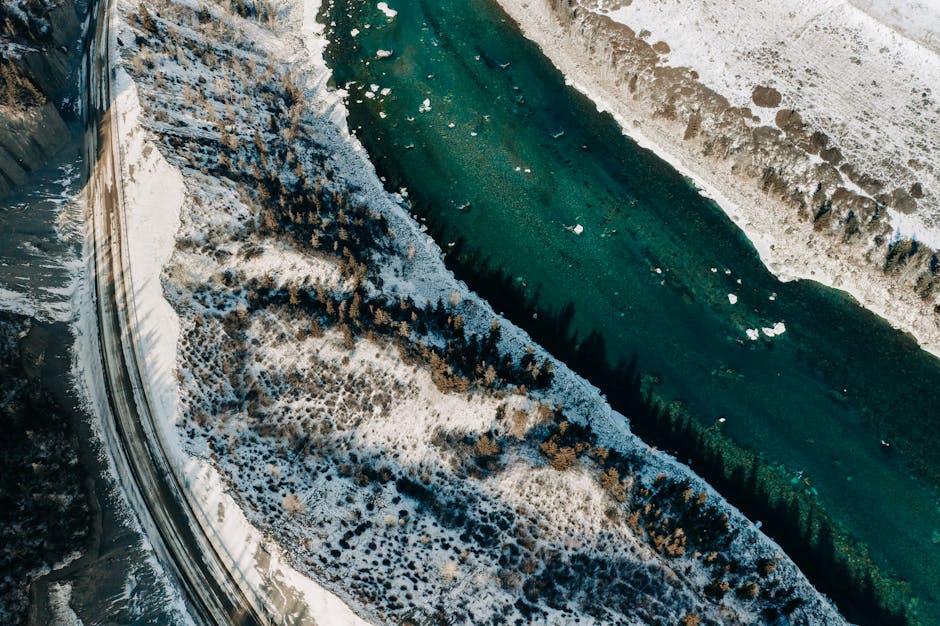 A stunning aerial view of a snow-covered landscape with a winding river in the Altai Mountains.