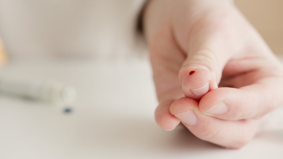 Close-up of a hand with a finger prick for home blood testing. Ideal for health and medical themes.