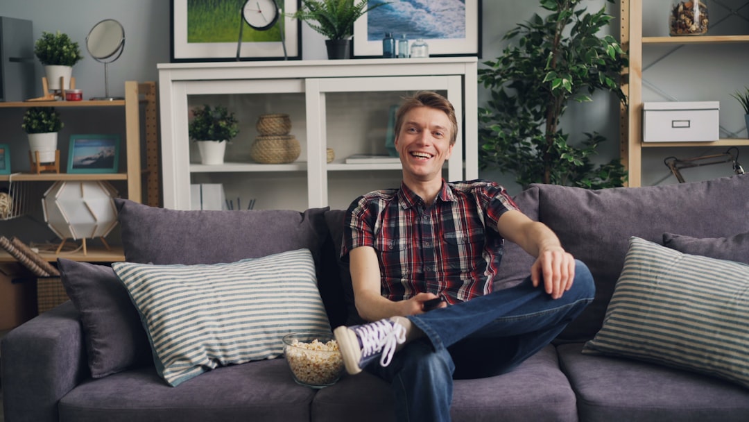 a man sitting on top of a couch in a living room