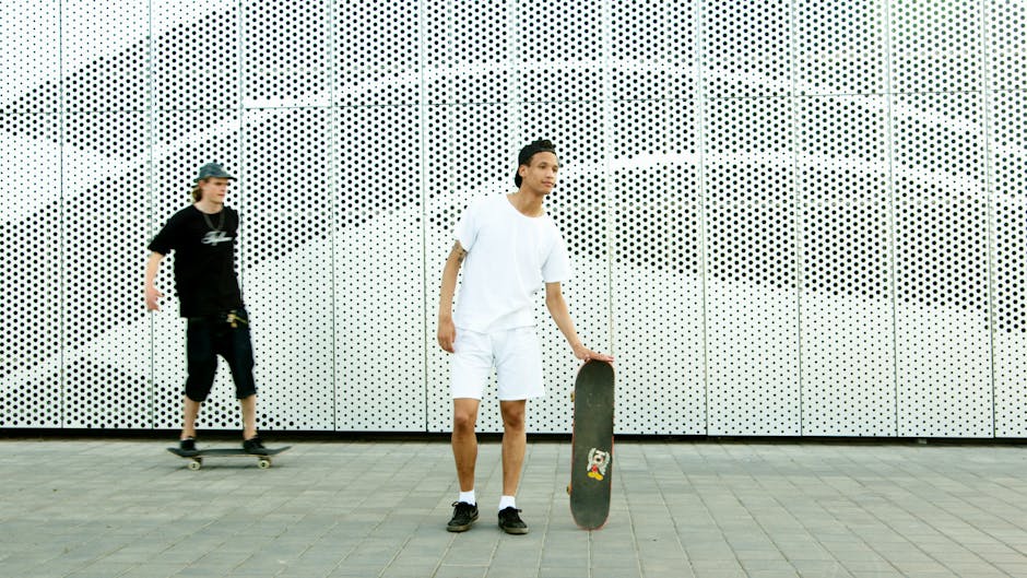 Two teenagers enjoying a skateboarding session in the city against a modern backdrop.