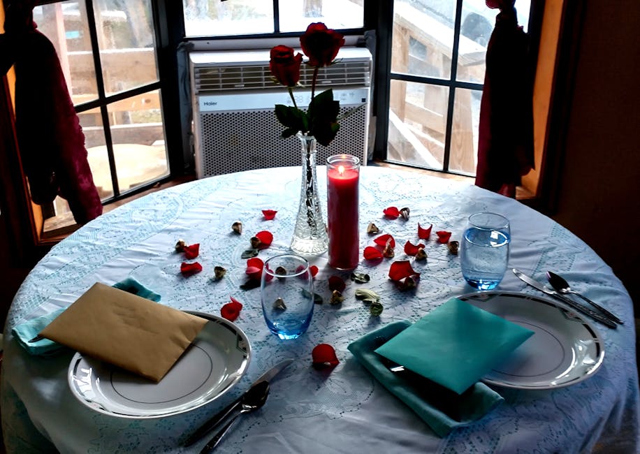 A beautifully arranged candlelit dinner table with roses, ready for a romantic evening.