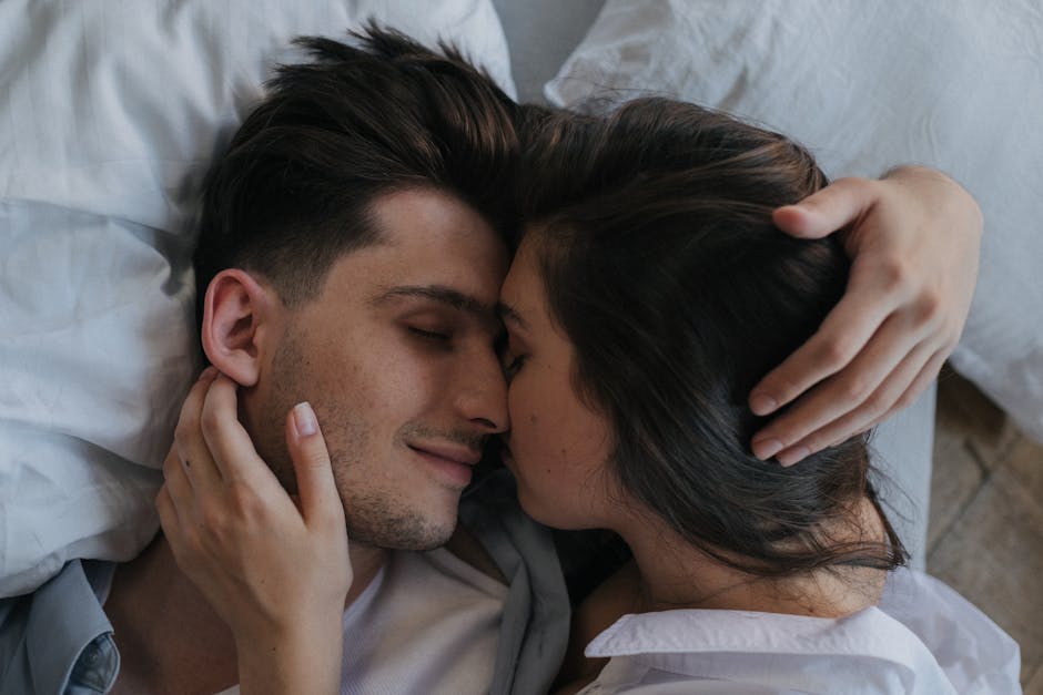 Close-up of a loving couple embracing and resting peacefully in bed.