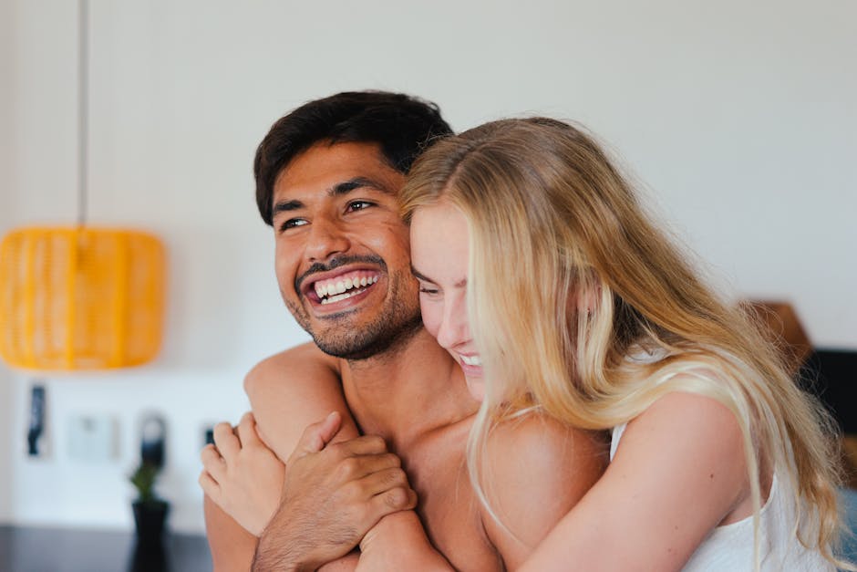Joyful couple embracing, exemplifying love and happiness in a home setting.