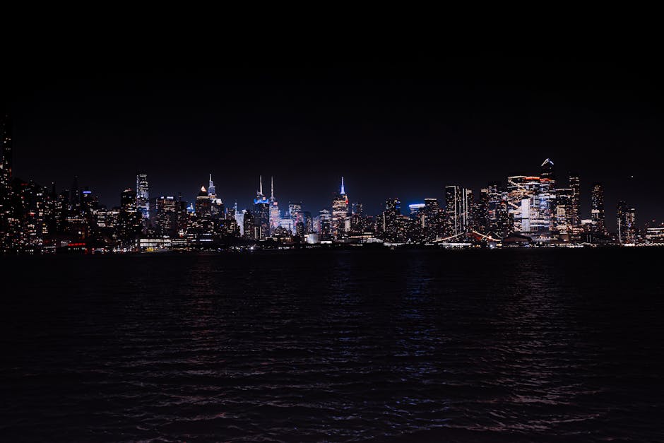 Breathtaking night view of the illuminated New York City skyline across the water.