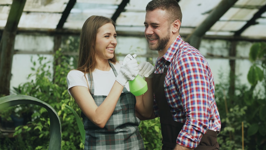 Couple high-fiving while working in a greenhouse.