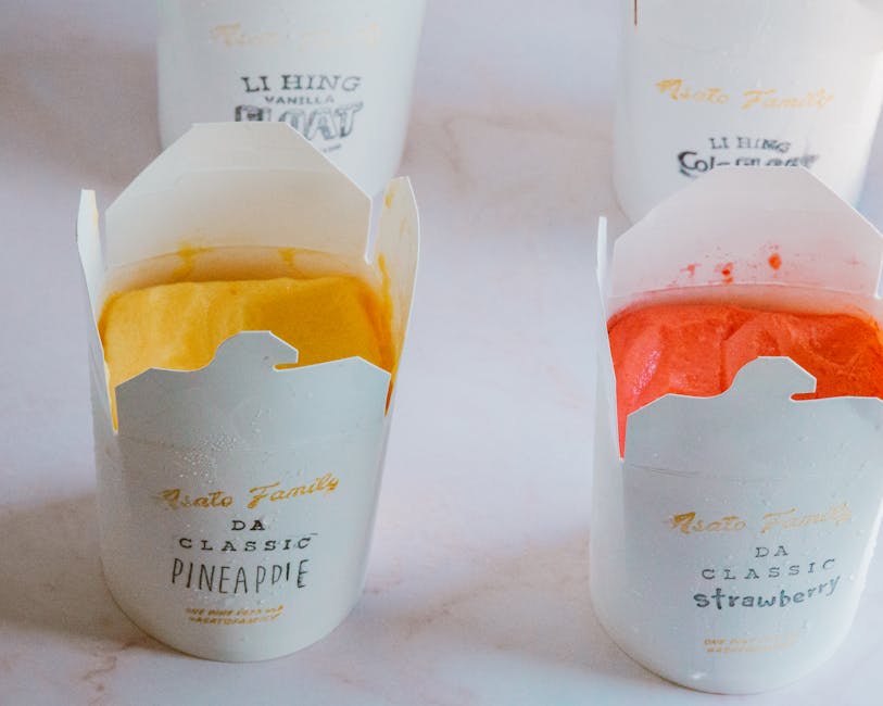 Close-up of fruity ice cream flavors in branded packaging, showcasing pineapple and strawberry varieties.