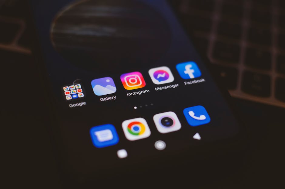 A smartphone displaying popular social media apps in a dimly lit environment, perfect for tech and communication themes.