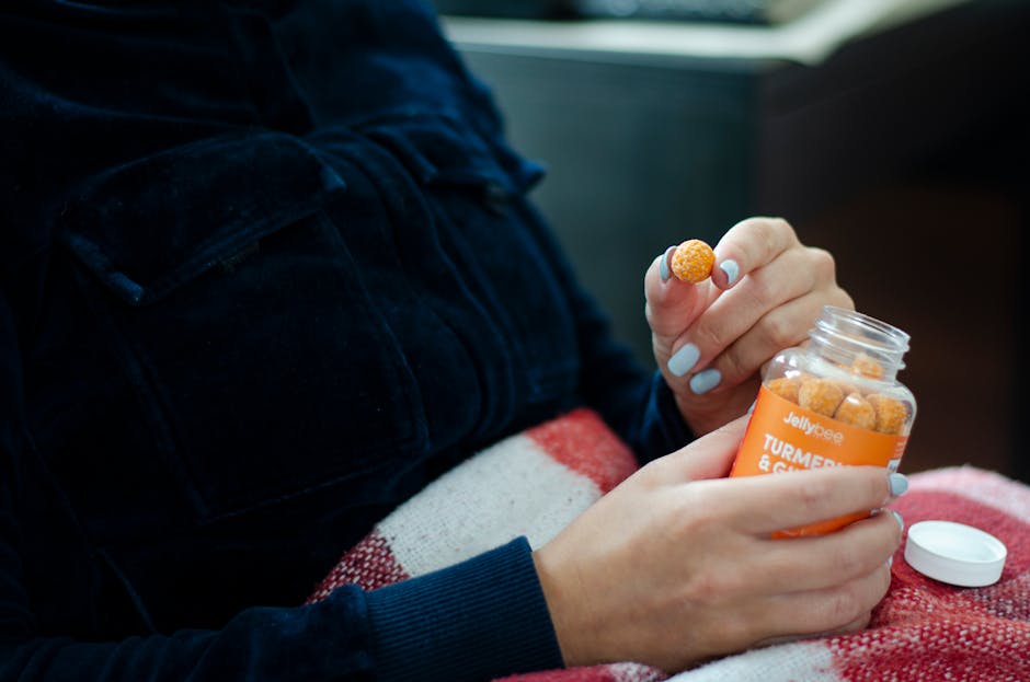 A person holding a bottle of turmeric gummies, showcasing their use as dietary supplements.