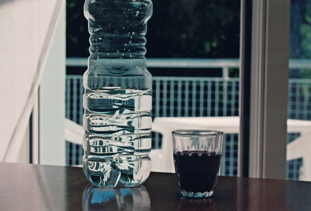 a glass bottle and a glass on a table